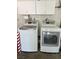 Convenient laundry area with modern washer and dryer, plus upper cabinets for efficient storage at 8940 Antioch Way, Las Vegas, NV 89117
