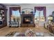 Elegant living room showcasing a stone fireplace, large windows, decorative furnishings, and tile flooring at 9270 Valerie Elaine St, Las Vegas, NV 89139