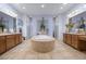 Luxurious main bathroom with a central tiled tub, dual vanities, and decorative floral arrangements at 9270 Valerie Elaine St, Las Vegas, NV 89139