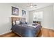 Cozy bedroom featuring hardwood floors, a ceiling fan, and a comfortable wooden bed frame at 9301 Queen Charlotte Dr, Las Vegas, NV 89145