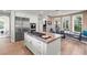 Modern kitchen with a large island, stainless steel appliances, and adjacent breakfast area at 9301 Queen Charlotte Dr, Las Vegas, NV 89145