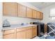 Bright laundry room offers built in cabinets, sink, counter space and modern appliances at 9301 Queen Charlotte Dr, Las Vegas, NV 89145