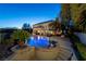 Night view of the pool with in-water bar stools and steps leading up to a waterfall feature at 9301 Queen Charlotte Dr, Las Vegas, NV 89145