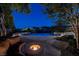 Serene pool area at night with a cozy fire pit, lounge seating, and ambient lighting at 9301 Queen Charlotte Dr, Las Vegas, NV 89145