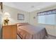 Carpeted bedroom with bed, dresser, fan, window with blinds, and light colored walls at , Henderson, NV 89074
