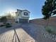 Charming two-story home features a two-car garage, brick driveway, and low-maintenance landscaping at 10148 Cluny Ave, Las Vegas, NV 89178