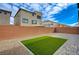 The backyard has an artificial turf, brick privacy wall, and a stone patio at 10198 Eden Mountain St, Las Vegas, NV 89141