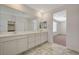 Elegant bathroom boasting marble floors, dual sinks, and a view into the adjacent bedroom at 10198 Eden Mountain St, Las Vegas, NV 89141