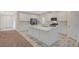 Bright, open kitchen with marble floors, stainless steel appliances, large island, and white cabinetry at 10198 Eden Mountain St, Las Vegas, NV 89141