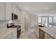 Open kitchen with stainless appliances, marble tile flooring and access to the living area at 10198 Eden Mountain St, Las Vegas, NV 89141