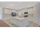 Modern kitchen boasts an island, stainless steel appliances, white cabinetry, and stunning marble-style floors at 10198 Eden Mountain St, Las Vegas, NV 89141