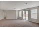 Bright, carpeted living area with a sliding glass door and large windows offering plenty of natural light at 10198 Eden Mountain St, Las Vegas, NV 89141