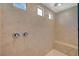 Modern shower boasts tan tiling, dual fixtures, a built-in bench and natural light at 10198 Eden Mountain St, Las Vegas, NV 89141