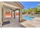 Covered patio overlooking a private pool, well-manicured landscaping, and block wall for privacy at 10506 Arnica Way, Las Vegas, NV 89135