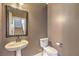 Powder room featuring a pedestal sink with framed mirror and a toilet at 10506 Arnica Way, Las Vegas, NV 89135