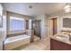 Bright bathroom featuring double sink vanity, separate tub, and a glass enclosed shower at 10506 Arnica Way, Las Vegas, NV 89135