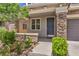 Inviting front entrance with stone accents, manicured landscaping, and a covered porch leading to the front door at 10506 Arnica Way, Las Vegas, NV 89135