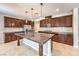 Spacious kitchen featuring dark wood cabinets, granite countertops, a large island, and stainless steel appliances at 10506 Arnica Way, Las Vegas, NV 89135