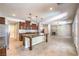 Open-concept kitchen with a large island, dark wood cabinetry, stainless steel appliances, flowing into the living room at 10506 Arnica Way, Las Vegas, NV 89135