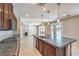 Modern kitchen with dark wood cabinets, granite island, stainless steel appliances, flowing into the living space at 10506 Arnica Way, Las Vegas, NV 89135