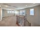 Open living area with plush carpet and an ornamental wood and iron stair railing at 10506 Arnica Way, Las Vegas, NV 89135