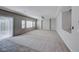 Large, bright living room with neutral carpet, windows, and access to the backyard at 10598 Aphrodite St, Las Vegas, NV 89183