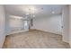 Bright living room with wood-look tile flooring, contemporary lighting, and neutral paint at 10598 Aphrodite St, Las Vegas, NV 89183