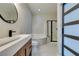 Stylish bathroom featuring double vanity, a soaking tub with a shower and a glass enclosure at 10908 Royal Highlands St, Las Vegas, NV 89141