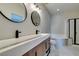 Modern bathroom with double vanity, sleek fixtures, soaking tub with shower and black framed glass at 10908 Royal Highlands St, Las Vegas, NV 89141