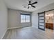 Bedroom showcasing wood-look floors, ceiling fan, and an ensuite bathroom behind a sliding barn door at 10908 Royal Highlands St, Las Vegas, NV 89141