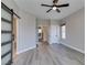 Bright bedroom with wood-look floors, ceiling fan and sliding barn door to the Primary bathroom at 10908 Royal Highlands St, Las Vegas, NV 89141