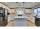 Modern kitchen featuring white cabinets, stainless steel appliances, large island, and stylish pendant lighting at 10908 Royal Highlands St, Las Vegas, NV 89141