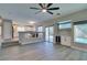 Open-concept living room featuring a built-in bar, light hardwood floors, and a view of the kitchen and pool at 10908 Royal Highlands St, Las Vegas, NV 89141