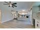 Bright living room features a ceiling fan, wood flooring, and wet bar with wine fridge at 10908 Royal Highlands St, Las Vegas, NV 89141