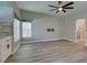 Bright living room with light hardwood floors, a ceiling fan, and a built-in bar at 10908 Royal Highlands St, Las Vegas, NV 89141