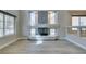 Spacious living room with a fireplace, large windows offering natural light, and stylish light wood flooring at 10908 Royal Highlands St, Las Vegas, NV 89141