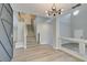 Open living room with hardwood floors, modern chandelier, and a staircase at 10908 Royal Highlands St, Las Vegas, NV 89141