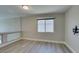 Bright, open room with hardwood floors, a window, and a wall-mounted TV bracket at 10908 Royal Highlands St, Las Vegas, NV 89141