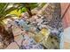 Backyard with a tranquil water feature, with lush vegetation and stone accents, offering a serene outdoor escape at 11764 Golden Moments Ave, Las Vegas, NV 89138