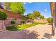 Beautiful backyard with well-maintained landscaping, brick laid patio, and a terraced wall feature at 11764 Golden Moments Ave, Las Vegas, NV 89138