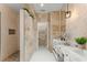 Luxurious bathroom with a glass enclosed shower, stone tile, double sinks, and modern fixtures at 11764 Golden Moments Ave, Las Vegas, NV 89138