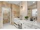 Elegant bathroom featuring double sinks, stone countertops, decorative mirrors, and tiled walls at 11764 Golden Moments Ave, Las Vegas, NV 89138