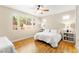 Bright bedroom with a ceiling fan, hardwood floors, and large windows providing lots of natural light at 11764 Golden Moments Ave, Las Vegas, NV 89138