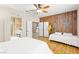 Cozy bedroom with a wood accent wall, hardwood floors, and ensuite bathroom and kitchen access at 11764 Golden Moments Ave, Las Vegas, NV 89138