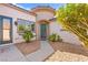 Charming front entrance with a turquoise front door, surrounded by a desert landscape, and an artistic architectural turret at 11764 Golden Moments Ave, Las Vegas, NV 89138