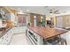Open kitchen with granite counters, white cabinets and large wood island with seating at 11764 Golden Moments Ave, Las Vegas, NV 89138
