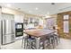 Bright kitchen features stainless steel appliances, island with seating, and stone accent wall at 11764 Golden Moments Ave, Las Vegas, NV 89138