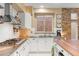 Stylish kitchen features stone accent wall, granite counters and white brick backsplash at 11764 Golden Moments Ave, Las Vegas, NV 89138