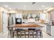 Bright kitchen featuring an island with seating, stainless steel appliances, and a farmhouse sink at 11764 Golden Moments Ave, Las Vegas, NV 89138