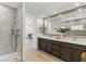 Bathroom with a double sink vanity, large mirror, and glass-enclosed shower at 11775 Woodbrook Ct, Las Vegas, NV 89141